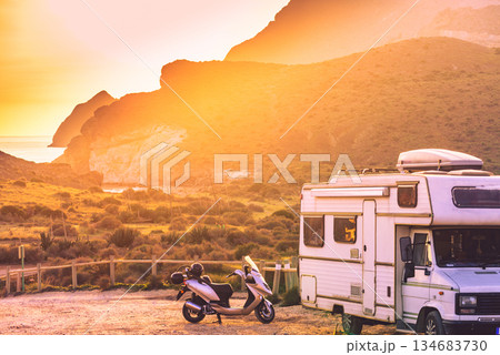 Scooter at camper camping on mountain nature at sunset. Scooter at camper camping on mountain nature at sunset. 134683730