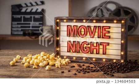 Movie night setup with snacks on a wooden table in a cozy room during evening hours 134684503