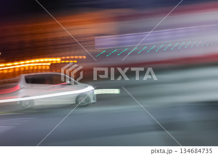 夜の都会をスピード走行する白い車 134684735