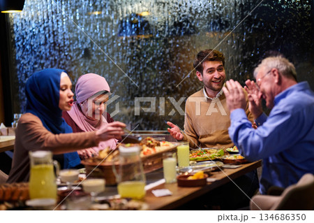 Muslim family enjoying iftar together in a restaurant with Ramadan decorations 134686350