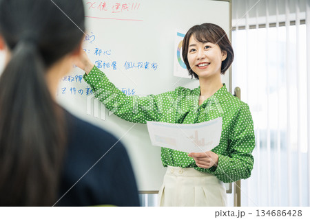 会議室で発表をする若いキャリアウーマン 134686428