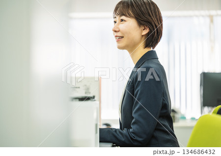 オフィスでデスクワークをする若い女性 オフィスでデスクワークをする若い女性 134686432