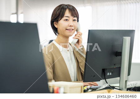 オフィスで電話応対をする若い女性 134686460