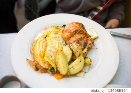 Breakfast Plate with Omelette, Croissant, and Roasted Potatoes 134686594