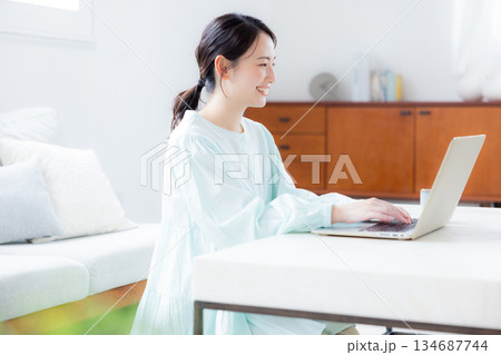 リビングでパソコンを使う女性 リビングでパソコンを使う女性 134687744