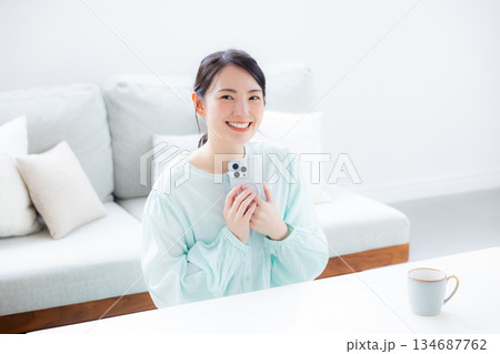 部屋でスマホを使う女性 部屋でスマホを使う女性 134687762