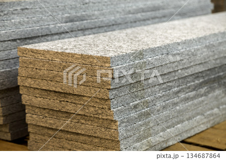 Piles of granite marble slabs. Stone sheets for decorative construction. 134687864
