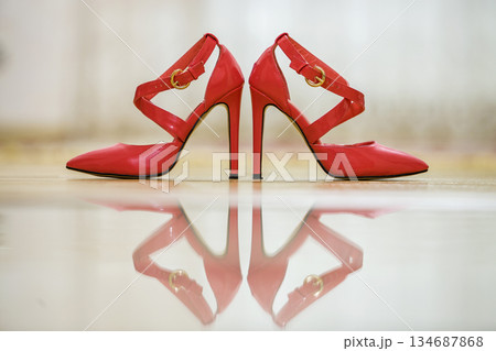 Pair of fashionable high heel leather red cut-out female shoes with golden buckles isolated on light copy space background. Style and fashion, modern footwear concept. Pair of fashionable high heel leather red cut-out female shoes with golden buckles isolated on light copy space background. Style and fashion, modern footwear concept. 134687868