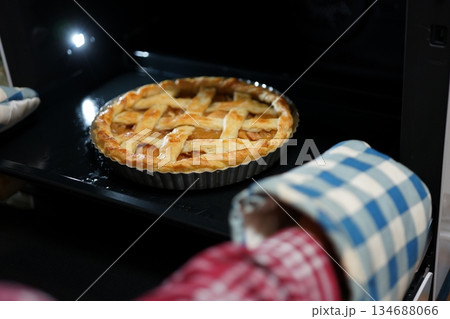 焼きあがったアップルパイを取り出す手元 134688066