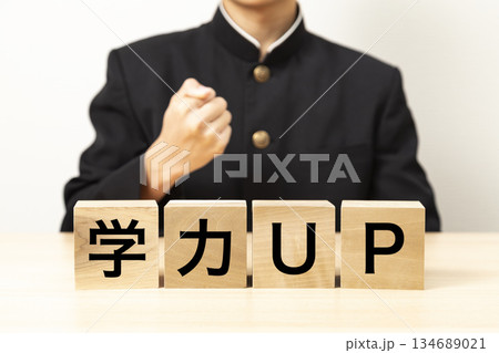 「学力UP」と書かれたブロックとガッツポーズをする男子学生 134689021