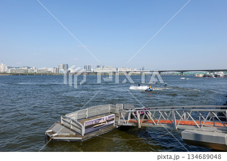 Scenic View of Yeouido Floating Water Taxi Dock on the Han River with City Skyline and Jetski Activities 134689048