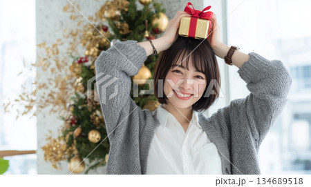 女性が白シャツ灰色ニットで帰宅後の微笑み 134689518