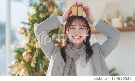 女性が白シャツ灰色ニットで帰宅後に笑顔 134689520