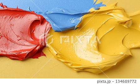 Bright and Vibrant Splashes of Red, Blue, and Yellow Acrylic Paint on Canvas Surface 134689772