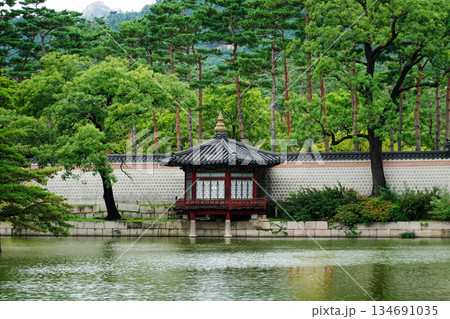Traditional Korean Pavilion Hyangyangjeong in the Serene Gardens of Gyeongbokgung Palace Surrounded by Lush Greenery and Mountains 134691035