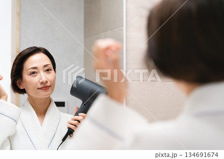 ドライヤーで髪を乾かしている女性 ビューティイメージ ドライヤーで髪を乾かしている女性 ビューティイメージ 134691674