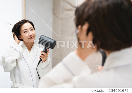 ドライヤーで髪を乾かしている女性 ビューティイメージ ドライヤーで髪を乾かしている女性 ビューティイメージ 134691675
