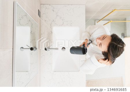 ドライヤーで髪を乾かしている女性 ビューティイメージ ドライヤーで髪を乾かしている女性 ビューティイメージ 134691685