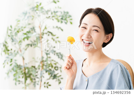 柿を食べる女性　食べ物イメージ 134692356