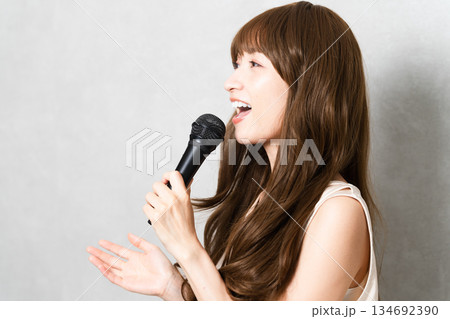 マイクを持って歌を歌う女性　ライフスタイルイメージ 134692390