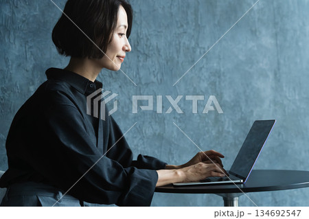 テーブルでラップトップを操作する女性 ライフスタイルイメージ テーブルでラップトップを操作する女性 ライフスタイルイメージ 134692547