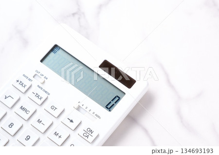 電卓 - テーブルの上に置かれた、白い電卓 134693193