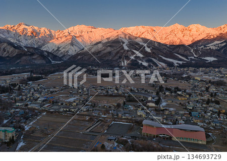 白馬連峰の美しいモルゲンロートと白馬村の街並み　長野県白馬村（ドローンによる空撮） 134693729