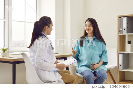 Smiling happy pregnant woman visiting her obstetrician doctor in maternity clinic. Smiling happy pregnant woman visiting her obstetrician doctor in maternity clinic. 134694609