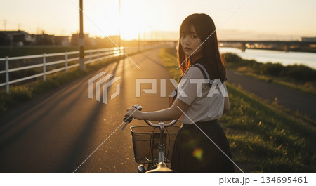 夕暮れ時の帰り道 自転車を押す女性 夕暮れ時の帰り道 自転車を押す女性 134695461