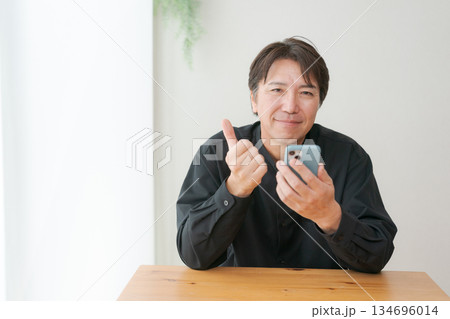 スマホを操作する中年男性 134696014
