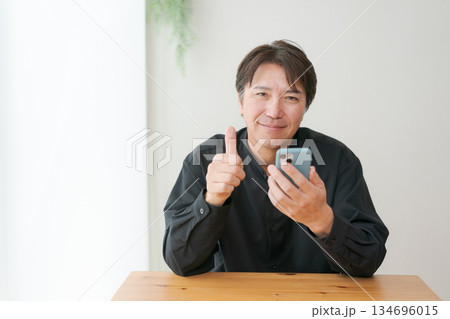 スマホを操作する中年男性 134696015