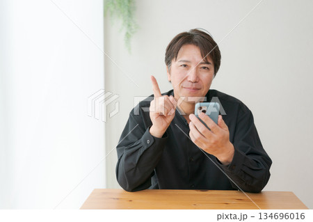 スマホを操作する中年男性 134696016