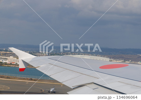 ホノルル空港を離陸した旅客機、眼下に見える滑走路と飛行機 ホノルル空港を離陸した旅客機、眼下に見える滑走路と飛行機 134696064