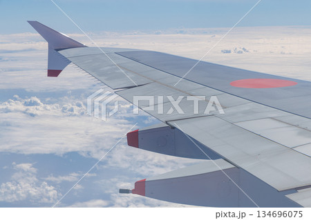 ジェット旅客機の翼と青空と雲 134696075