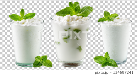 Ayran salted yogurt drink in tall glass with foamy top and mint leaf, isolated on white background, concept of healthy drink Ayran salted yogurt drink in tall glass with foamy top and mint leaf, isolated on white background, concept of healthy drink 134697241