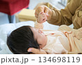 Newborn baby held in mother arms while clasping mother finger with tiny hand on bed at home 134698119