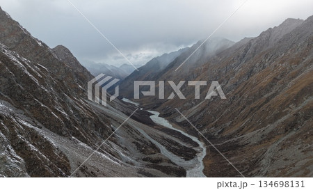 Majestic mountain valley with winding river and dramatic cloud cover 134698131