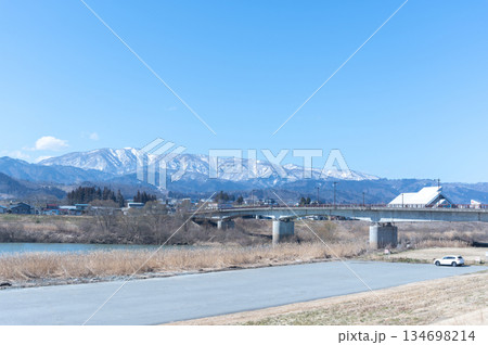 最上川にかかる橋と雪山 134698214
