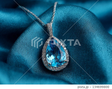 Blue topaz pendant, luxury diamond jewelry, macro photo on silk texture. Elegant silver chain, clear gemstone, expensive beauty concept. Beautiful blue topaz pendant. Blue topaz pendant, luxury diamond jewelry, macro photo on silk texture. Elegant silver chain, clear gemstone, expensive beauty concept. Beautiful blue topaz pendant. 134699800