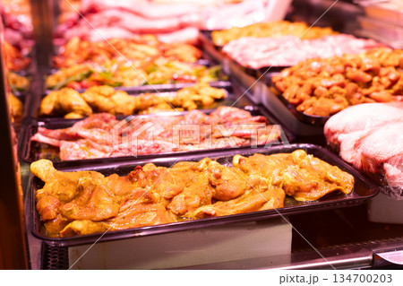 Meat department of store sells chicken meat marinated with addition of curry seasoning. 134700203