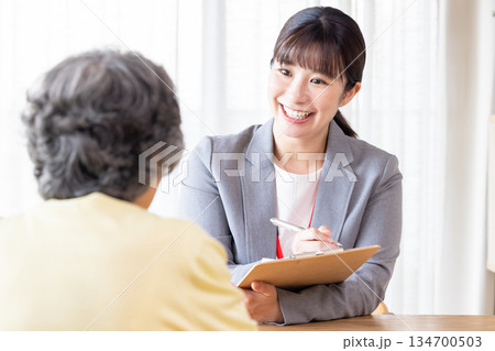 シニア女性に説明するビジネスウーマン シニア女性に説明するビジネスウーマン 134700503