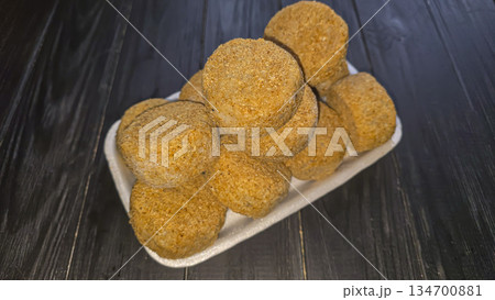 Freshly frozen breaded fish cakes. Round, semi-finished products, ready to cook. 134700881