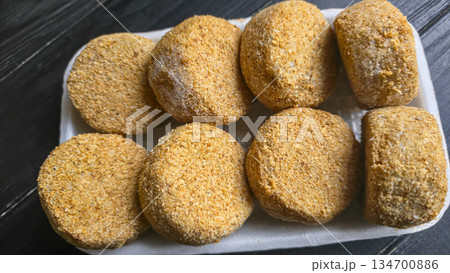 Freshly frozen breaded fish cakes. Round, semi-finished products, ready to cook. Freshly frozen breaded fish cakes. Round, semi-finished products, ready to cook. 134700886