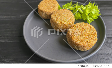 Freshly frozen breaded fish cakes. Round, semi-finished products, ready to cook. 134700887