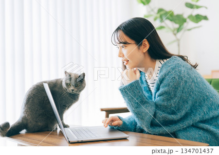 女性と一緒にパソコンを見る猫 134701437
