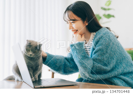 女性と一緒にパソコンを見る猫 134701448