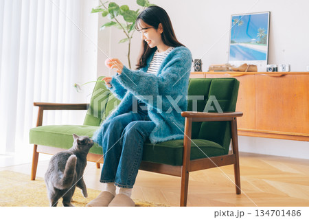 リビングで猫と遊ぶ女性 134701486