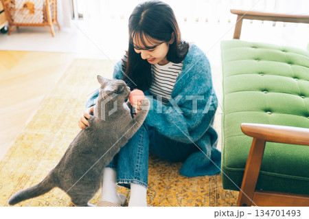 リビングで猫と遊ぶ女性 134701493