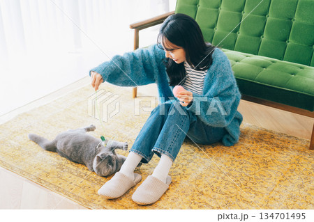 リビングで猫と遊ぶ女性 リビングで猫と遊ぶ女性 134701495