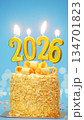 Happy New Year 2026, cute cake with golden ribbon with candle number 2026 for new year celebrate party was lit. blue background with light bokeh, vertical 134701823